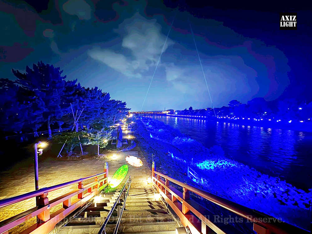 京の七夕 in Uji実施写真（1）宇治川ライトアップ！宇治の地において天空演出「天の川の出会い」を開催。一年に一度出会う天の川を夜空に描く、壮大な天空の七夕ショーを開催！“一年に一度、願いごとをする”という古くから伝わる七夕の節句の意義や云われを見つめ直し、その伝統を引き継ぎつつ、京都ならではの現代版・七夕まつりとして、京都各地で開催される「京の七夕」と融合して、宇治の風情を醸し出す情緒豊かな「京の七夕 in Uji」を開催いたします。※光りの演出＆ライトアップ＆イルミネーション＆プロジェクションランタン＆投影提灯＆手持ち提灯＆京の七夕。Lighting production and design by AXIZLight, and lighting designer KITATOSHI