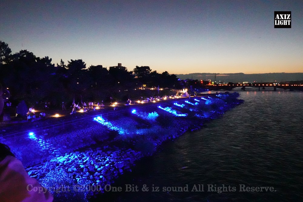 京の七夕 in Uji実施写真（34）宇治川ライトアップ＆京都ライトアップ！宇治の地において天空演出「天の川の出会い」を開催。一年に一度出会う天の川を夜空に描く、壮大な天空の七夕ショーを開催！“一年に一度、願いごとをする”という古くから伝わる七夕の節句の意義や云われを見つめ直し、その伝統を引き継ぎつつ、京都ならではの現代版・七夕まつりとして、京都各地で開催される「京の七夕」と融合して、宇治の風情を醸し出す情緒豊かな「京の七夕 in Uji」を開催いたします。※光りの演出＆ライトアップ＆イルミネーション＆プロジェクションランタン＆投影提灯＆手持ち提灯＆京の七夕。Lighting production and design by AXIZLight, and lighting designer KITATOSHI
／京の七夕 in Ujiイベント運営＆京の七夕 in UjiライトアッププロデュースOneBit（ワンビット）& AXIZ Light（アクシーズライト）& あくち～む（京都ライトアップ照明プロデュースLighting production, 京都イベントプロデュース,京都ライトアップ照明デザインlighting design, 照明デジタルプログラムdigital program）