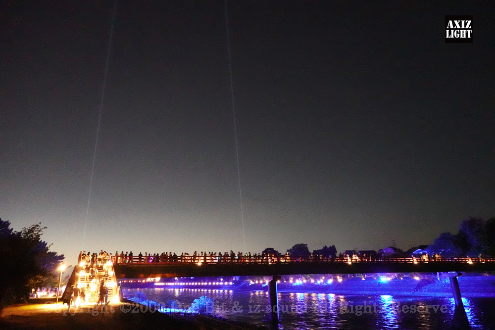 京の七夕 in Uji実施写真（19）宇治川ライトアップ＆京都ライトアップ！宇治の地において天空演出「天の川の出会い」を開催。一年に一度出会う天の川を夜空に描く、壮大な天空の七夕ショーを開催！“一年に一度、願いごとをする”という古くから伝わる七夕の節句の意義や云われを見つめ直し、その伝統を引き継ぎつつ、京都ならではの現代版・七夕まつりとして、京都各地で開催される「京の七夕」と融合して、宇治の風情を醸し出す情緒豊かな「京の七夕 in Uji」を開催いたします。※光りの演出＆ライトアップ＆イルミネーション＆プロジェクションランタン＆投影提灯＆手持ち提灯＆京の七夕。Lighting production and design by AXIZLight, and lighting designer KITATOSHI
／京の七夕 in Ujiイベント運営＆京の七夕 in UjiライトアッププロデュースOneBit（ワンビット）& AXIZ Light（アクシーズライト）& あくち～む（京都ライトアップ照明プロデュースLighting production, 京都イベントプロデュース,京都ライトアップ照明デザインlighting design, 照明デジタルプログラムdigital program）