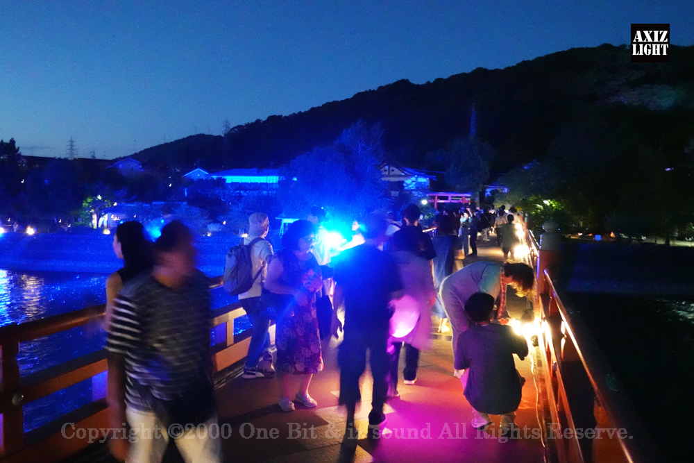 京の七夕 in Uji実施写真（7）宇治川ライトアップ＆京都ライトアップ！宇治の地において天空演出「天の川の出会い」を開催。一年に一度出会う天の川を夜空に描く、壮大な天空の七夕ショーを開催！“一年に一度、願いごとをする”という古くから伝わる七夕の節句の意義や云われを見つめ直し、その伝統を引き継ぎつつ、京都ならではの現代版・七夕まつりとして、京都各地で開催される「京の七夕」と融合して、宇治の風情を醸し出す情緒豊かな「京の七夕 in Uji」を開催いたします。※光りの演出＆ライトアップ＆イルミネーション＆プロジェクションランタン＆投影提灯＆手持ち提灯＆京の七夕。Lighting production and design by AXIZLight, and lighting designer KITATOSHI
／京の七夕 in Ujiイベント運営＆京の七夕 in UjiライトアッププロデュースOneBit（ワンビット）& AXIZ Light（アクシーズライト）& あくち～む（京都ライトアップ照明プロデュースLighting production, 京都イベントプロデュース,京都ライトアップ照明デザインlighting design, 照明デジタルプログラムdigital program）